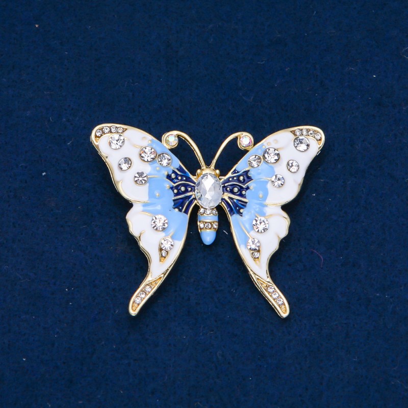 Broszka Motylek z metalu złocistego, emalii i kryształami strass w kolorze białym i benzynowym, 52×42 mm