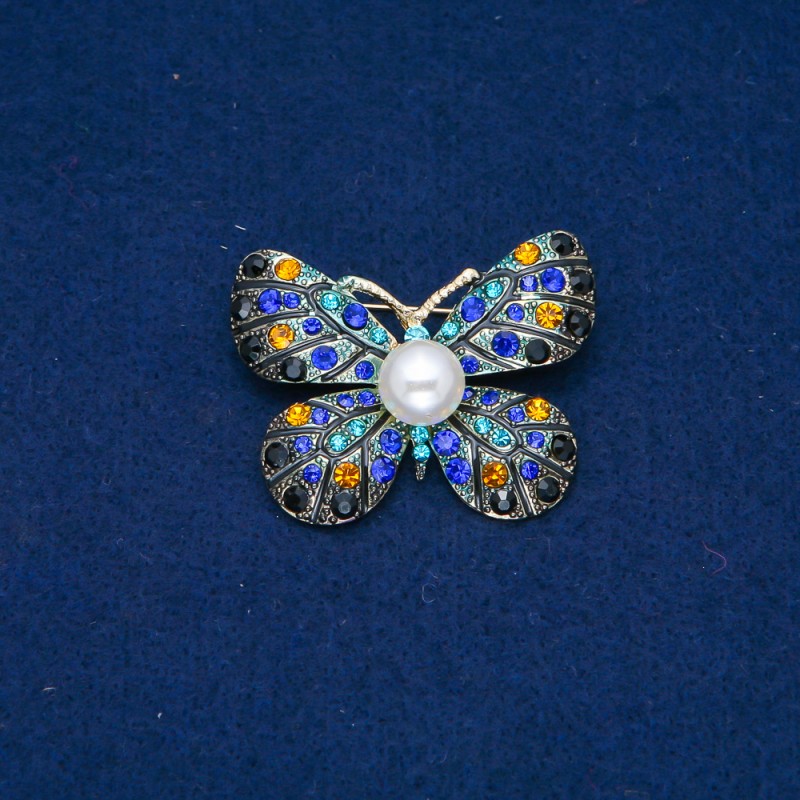 Broszka Motyl w złocistym metalu, żółte, niebieskie i czarne strassy i koralik 32×42 mm +