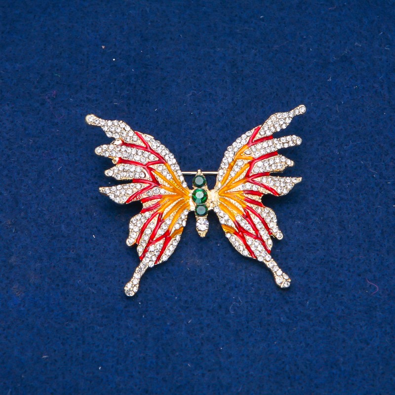 Broszka Motyl – metal złocisty, emalia i białe oraz zielone kryształy strassowe, 42×50 mm +