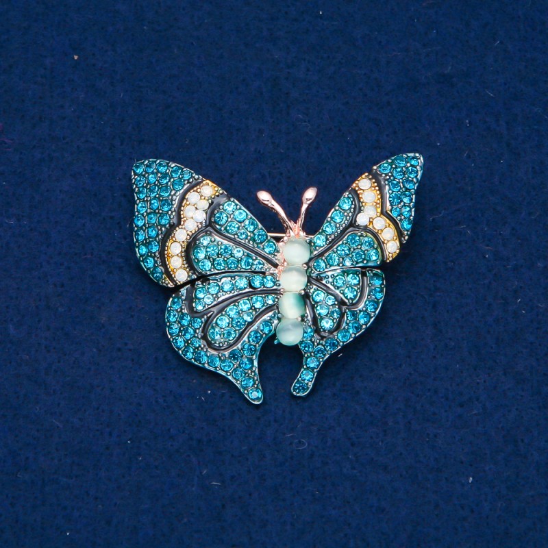 Broszka Motyl z metalu złocistego, błękitne i białe kryształki i koraliki 37×45 mm