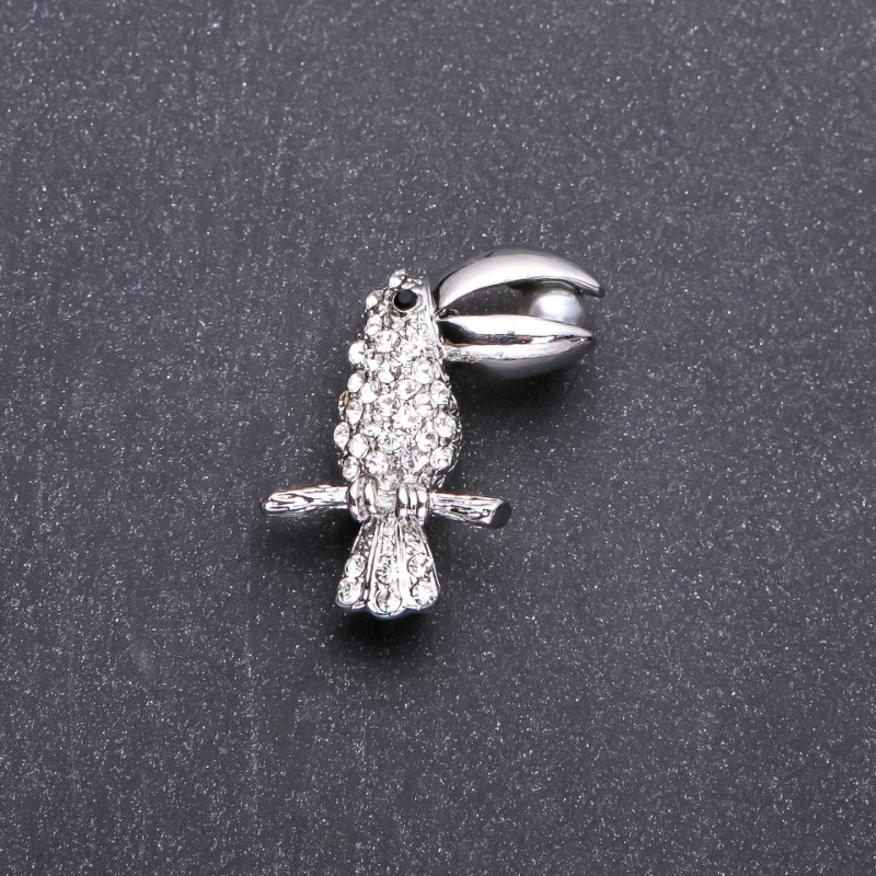 Broszka Tukana z białymi kryształami, 32×20 mm, biały metal