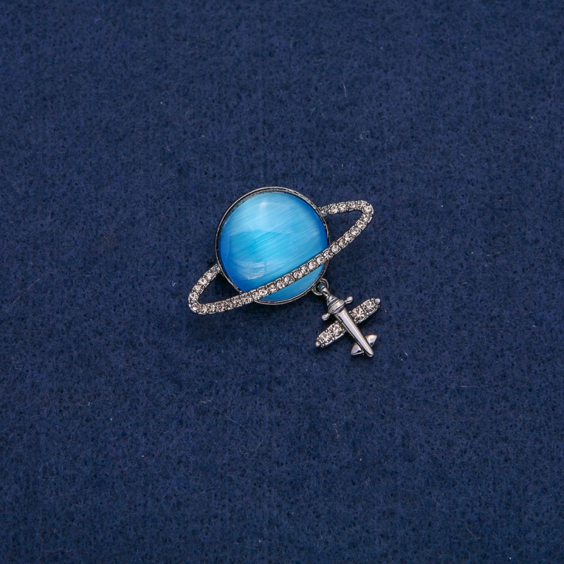 Broszka Saturn Kocie oko z samolotem, ciemny metal z białymi strassami 35×20 mm +