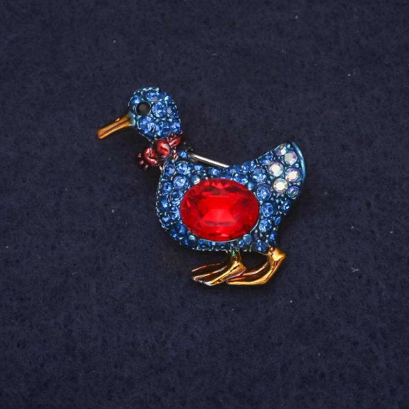Broszka w kształcie kaczątka z niebieskimi kryształami i czerwonym kryształem 24×30 mm