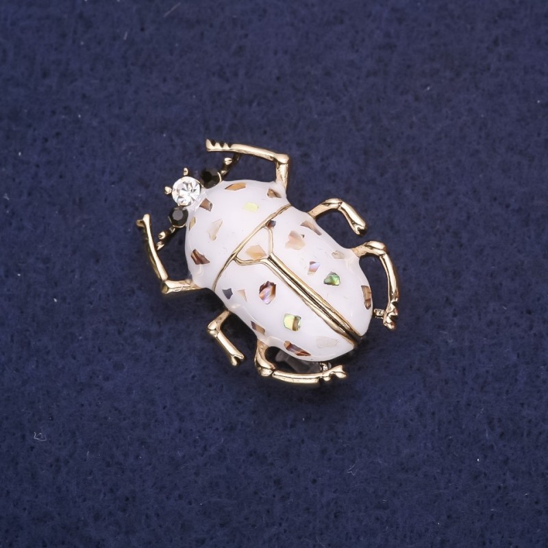 Broszka Żuk z białą emalią i haliozytem, 33×24 mm, żółty metal
