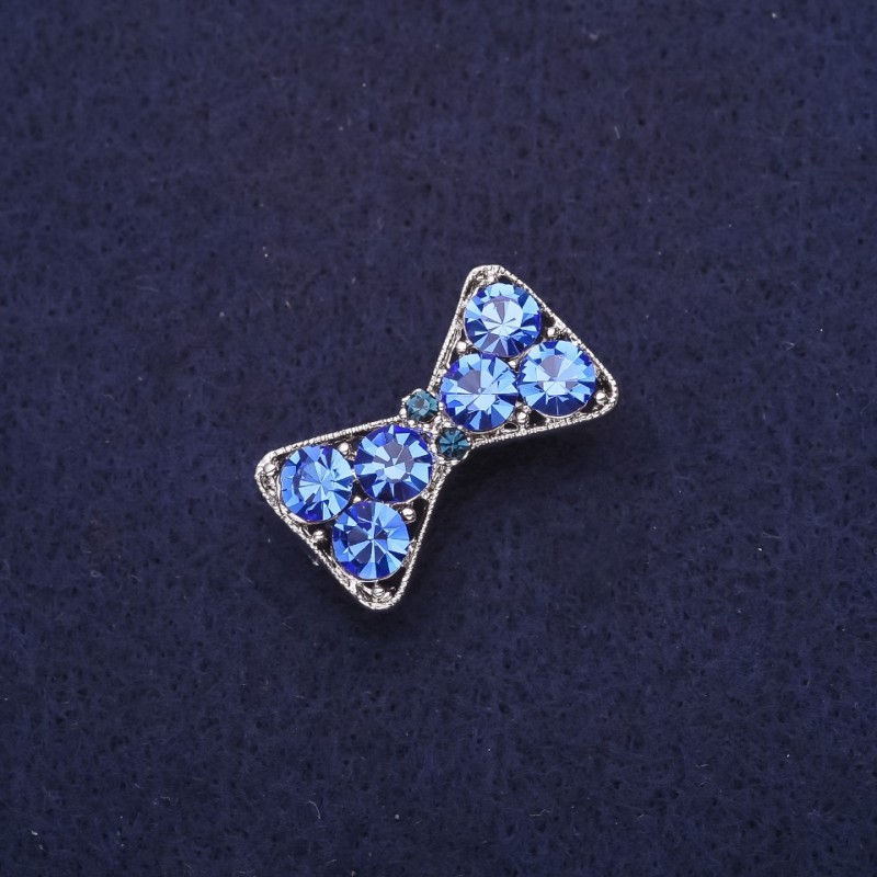 Broszka w formie kokardy z niebieskimi cyrkonami, srebrzysty metal, 27×16 mm