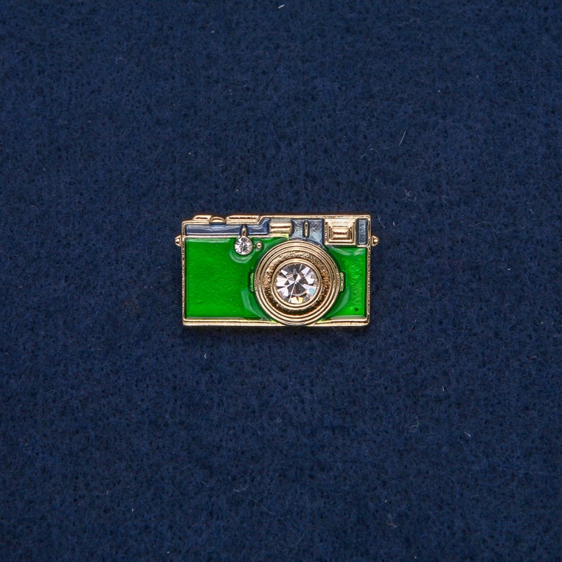 Broszka Aparat fotograficzny z metalu złocistego z zieloną emalią i białymi kamieniami 30×17 mm +