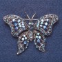 Broszka «Motyl» z niebieskimi kryształami w kolorze kameleona, kolor metalu: srebrny, 6×4 cm