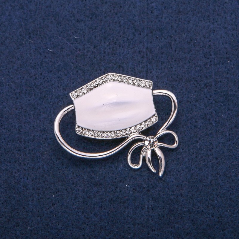 Broszka z motywem maski, biała emalia i strass, metal srebrzysty 37×41 mm
