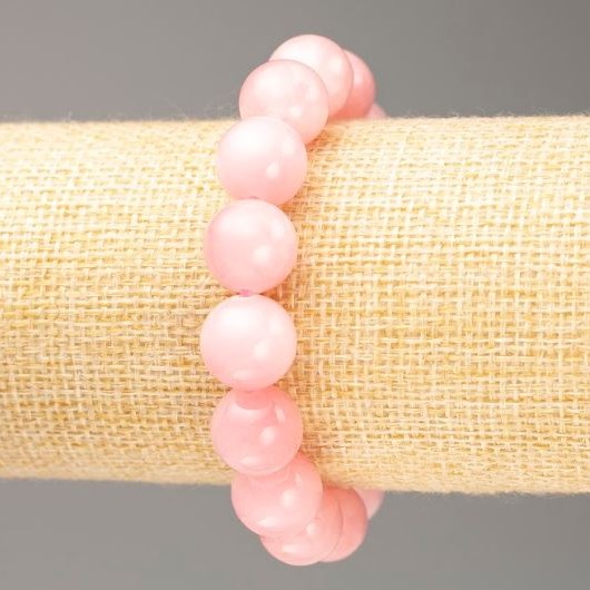 Bransoletka na gumce z różowego kwarcu (sztuczny akryl) gładka kulka, średnica 12,5 mm, długość 18 cm.