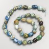 Koraliki z naturalnych kamieni: chryzokola i sodalit, fasetowane na nitce, średnica 8×10 mm, długość ok. 40 cm.