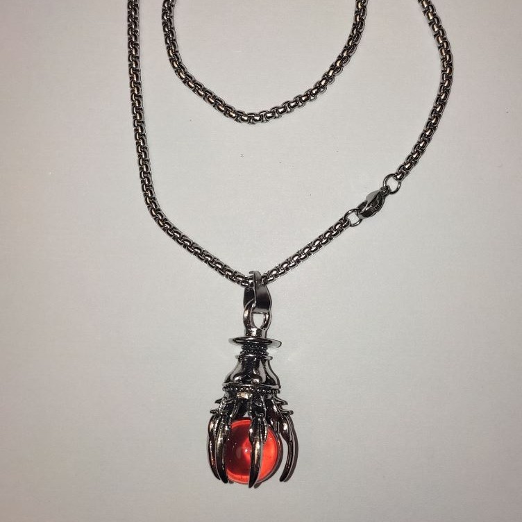 Wisiorek „Kulka w łapie” pomarańczowy, 40×18 mm na łańcuszku, długość około 70 cm, metal srebrzysty