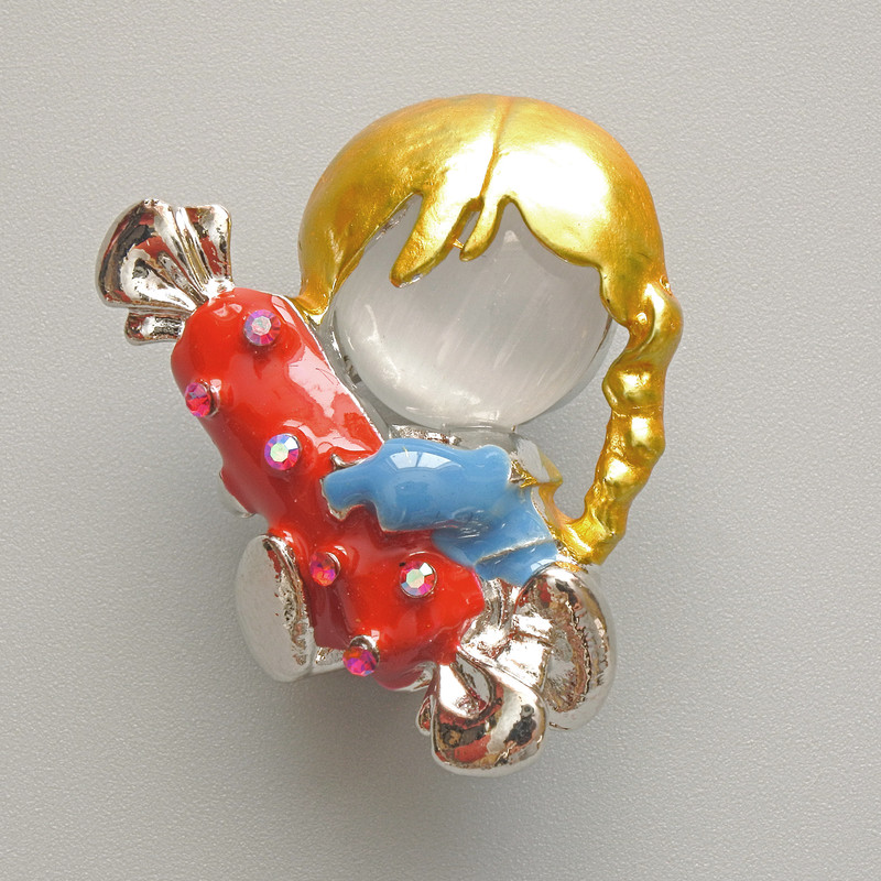Broszka „Dziewczynka z cukierkiem” z białym kocim okiem, czerwoną i niebieską emalią, strassami w kolorze chameleon, metal srebrny 25×30 mm