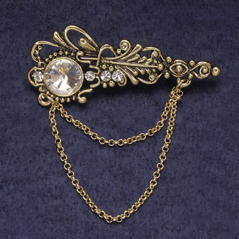 Broszka Akcent z białymi kryształkami i centralnym kryształem, metal złocisty 55×22 mm