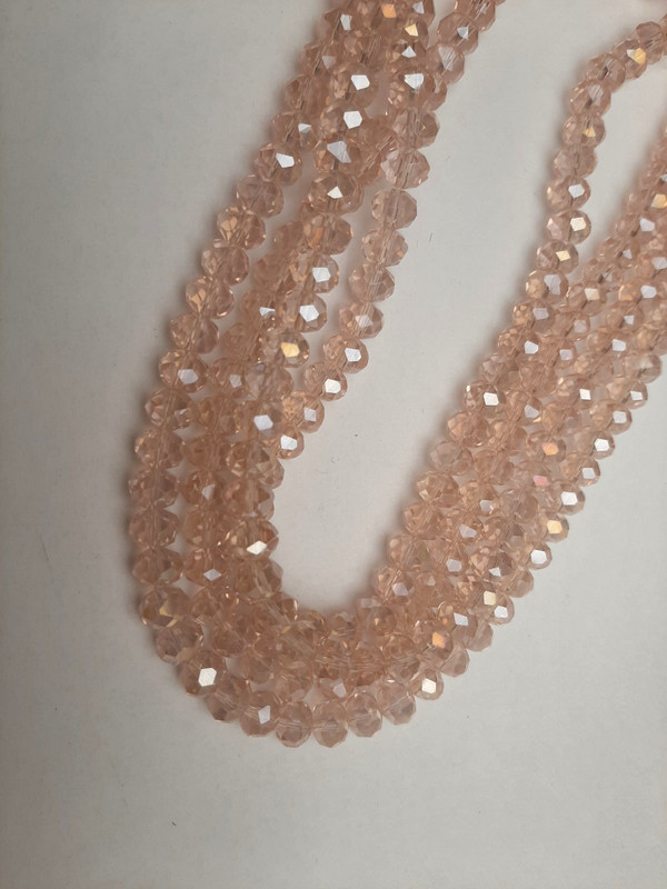 Koraliki czeskiego kryształu jasnoróżowe, przezroczyste, fasetowane rondelki z odcieniem benzynowym, średnica 8×6 mm, długość 39 mm, na żyłce