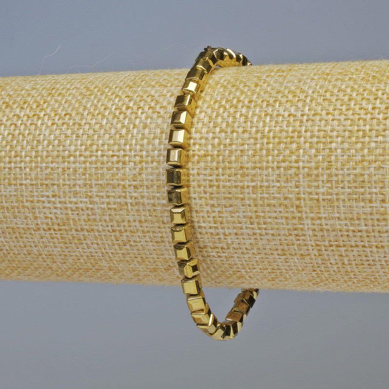 Bransoletka z hematytu – kostki w kolorze ciemnego złota, o wymiarach 4×4 mm, długość 18 cm, elastyczna