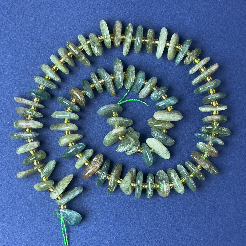 Koraliki z turmalinu w formie drobinek 10×4 mm ±, z koralikami o średnicy 2 mm ±, na nitce o długości 40 cm+