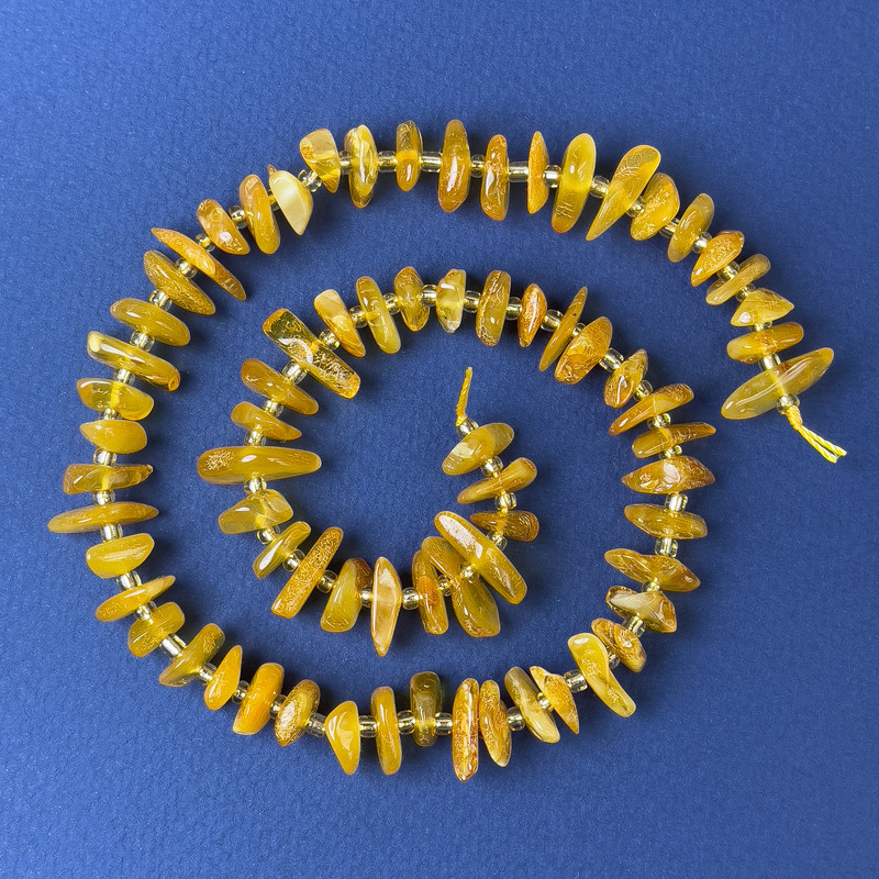 Koraliki bursztynowe – kruszyny bursztynu 10×3 mm ± z koralikami, średnica 3 mm ±, na nici, długość 38 cm ±