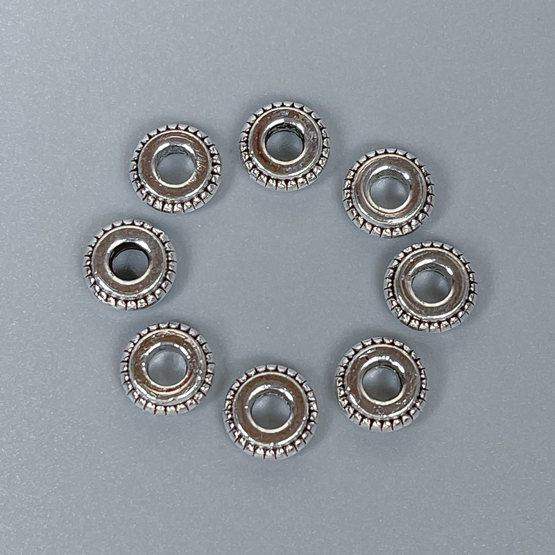 Koralik-wkładka o kolorze metalu srebrnym, średnica 7×3 mm, otwór ~3 mm, opakowanie 20 g (~45 szt.)