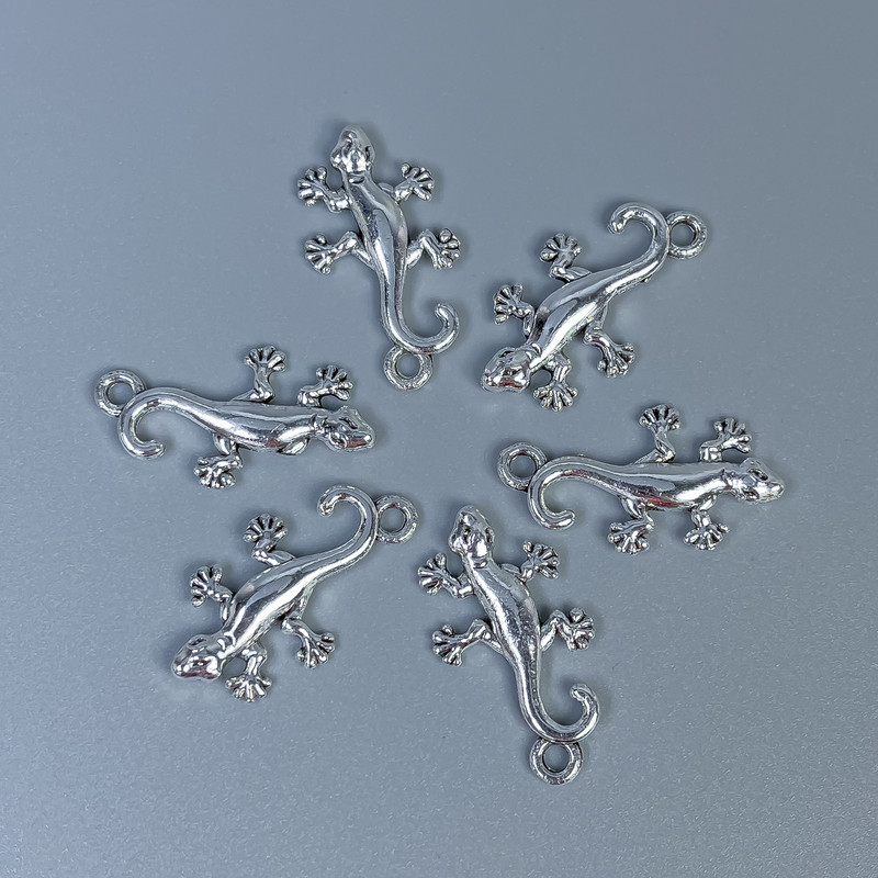 Zawieszka – galanteria jubilerska „Jaszczurka”, kolor srebrny, wymiary 23×13×2 mm, otwór 2 mm, opakowanie 12 szt.