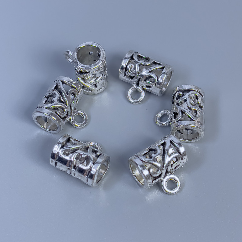 Zawieszka bail w kolorze metalu: srebro, wymiary 11×8×11 mm +/- otwory, średnica 5 mm +/-, średnica 2 mm +/- opakowanie 14 szt.