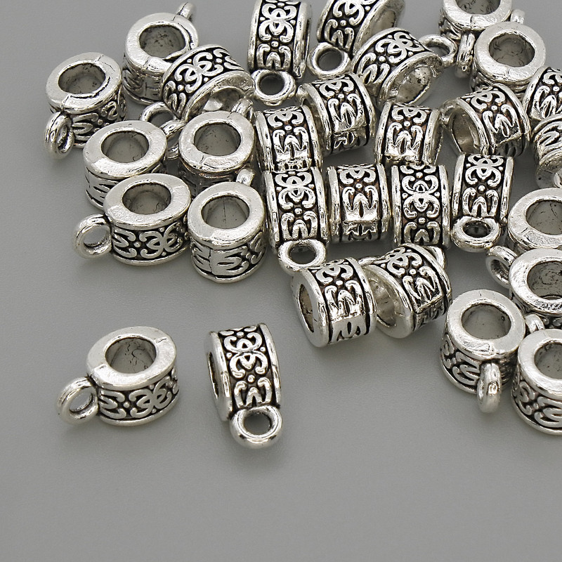 Zawieszka bail w kolorze srebrnym, wymiary 6×5×10 mm ± otwory 4 mm i 2 mm ±, opakowanie 20 g (~30 szt.)