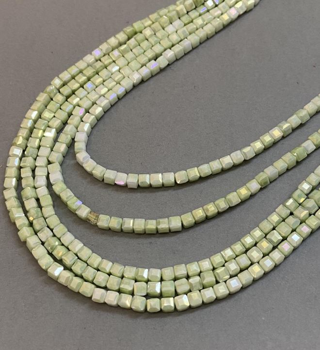 Koraliki czeskiego kryształu w kolorze zieleni sałatkowej z powłoką benzynową na nitce, fasetowany sześcian, średnica 4x4 mm, długość 38 cm