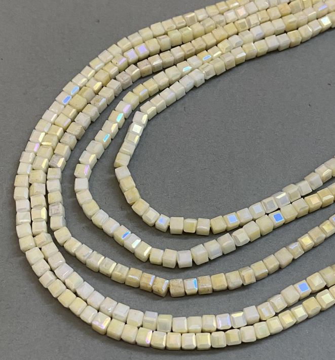 Koraliki czeskiego kryształu żółte z nalotem benzynowym, na nitce, oszlifowane kostki 4x4 mm, długość 38 cm