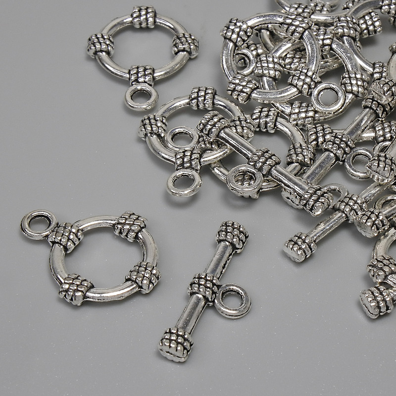 Okucie zapięcia toglowego, średnica koła około 14 mm, trzpień 19,5×3,5 mm, średnica otworu 9 mm, kolor metalu: srebrzysty, zestaw 11 szt.