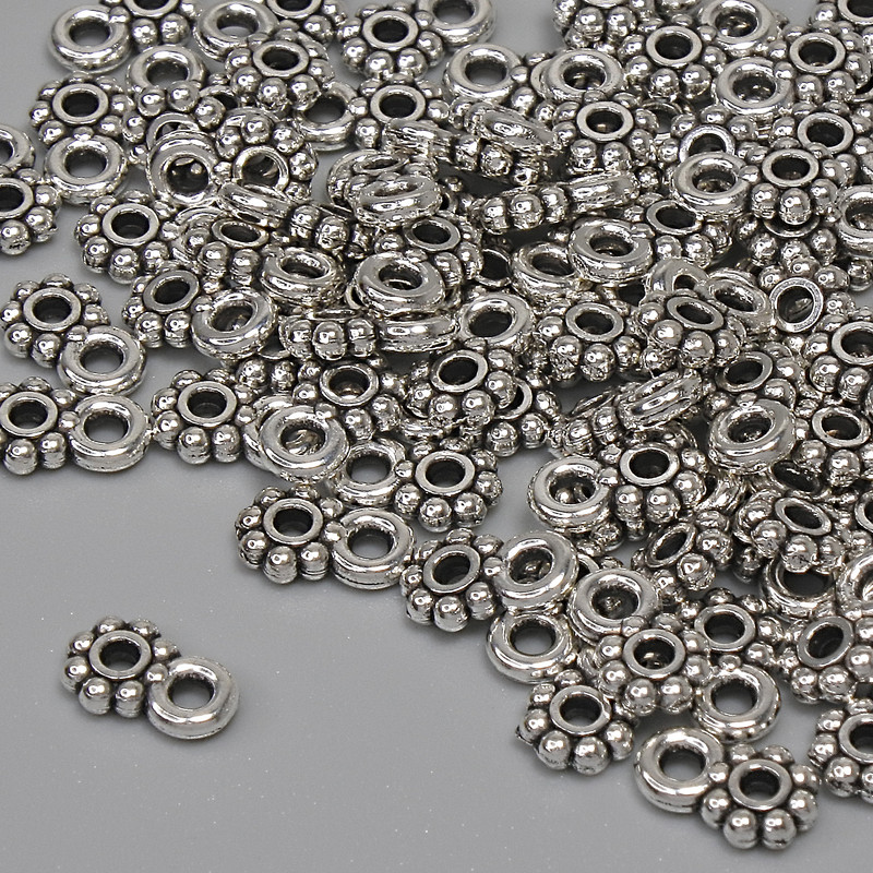 Zawieszka w kolorze metalu – srebro, wymiary 7×4,5 mm, otwór uszka 1,5 mm, opakowanie 84 szt.