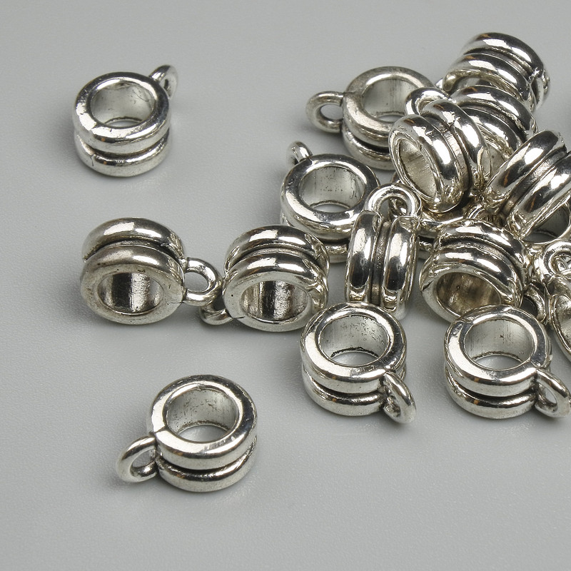 Zawieszka bail kolor metalu srebrzysty, wymiary 9×4 mm, otwory o średnicach około 2 mm i 4,8 mm, opakowanie 19 szt.