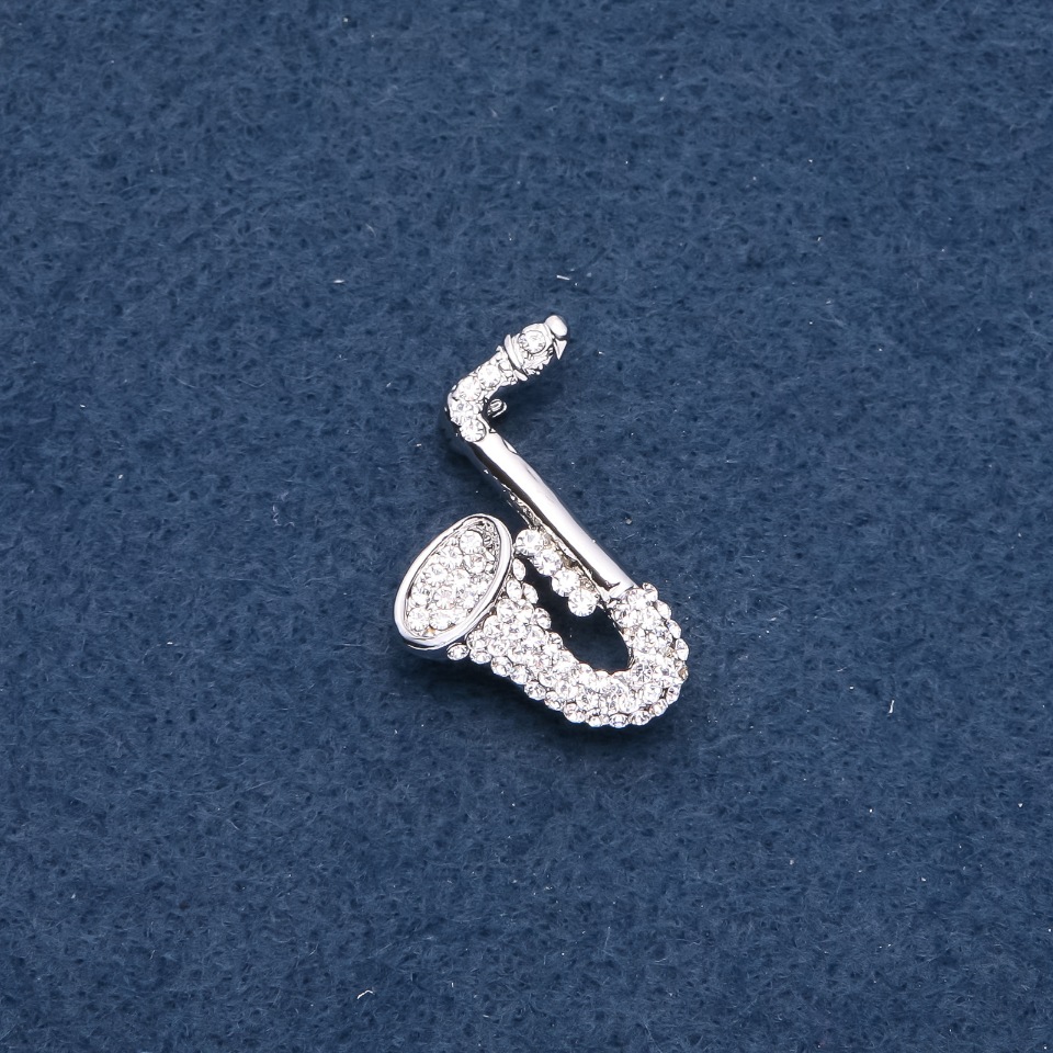 Broszka muzyczna «Saksofon» 28×25 mm kolor metalu «srebro»