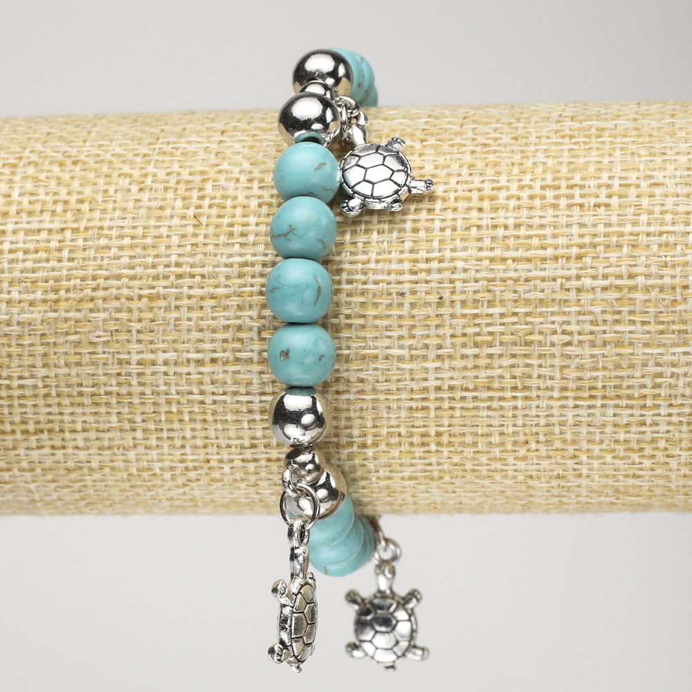 Bransoletka z turkusem (sztucznym) na elastycznej gumce, średnica około 8 mm ±, z srebrzystymi wstawkami i dekoracyjnymi żółwiami, długość 18 cm+