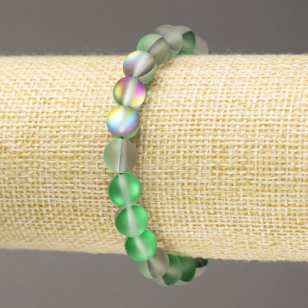 Bransoletka na gumce ze szkła opalowego, gładkie kule w odcieniu szaro-zielonym, matowe, średnica 8 mm, długość 18 cm.