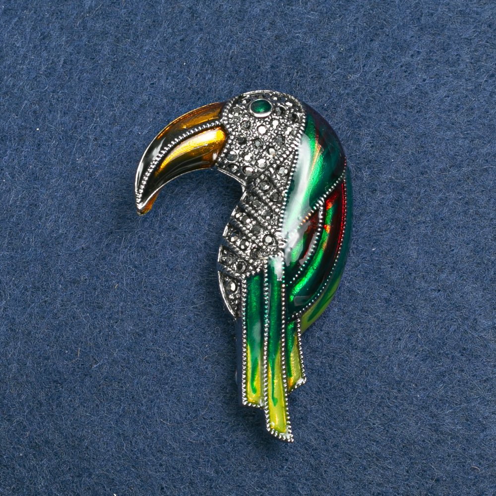 Broszka Tukana ze srebrzystego metalu, emalii i kryształów, 36×16 mm +