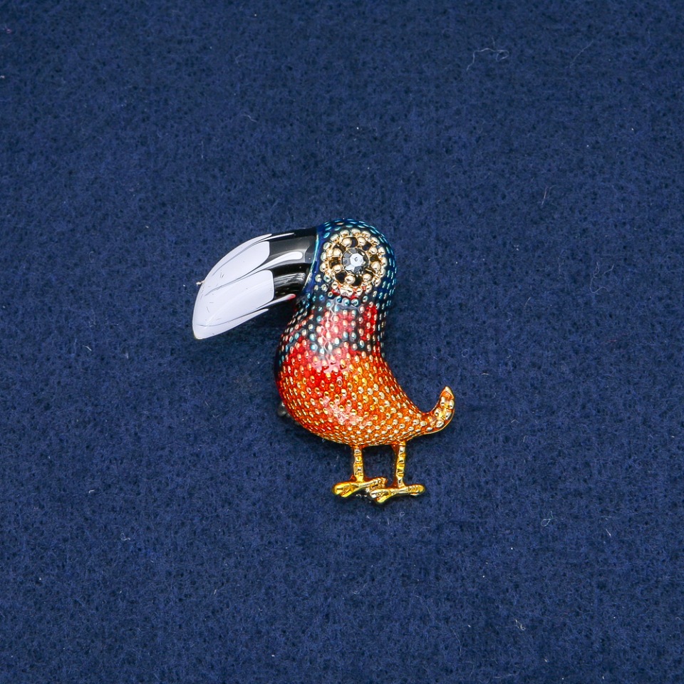 Broszka Tukana, czarno-biała emalia, szara cyrkonia, metal złocisty 40×35 mm +