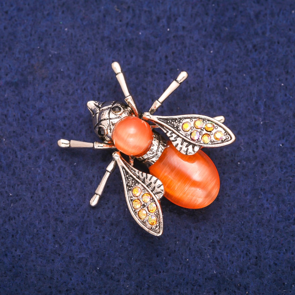 Broszka Motyl z pomarańczowym kocim okiem i cyrkoniami 33×34 mm, metal o złotym odcieniu