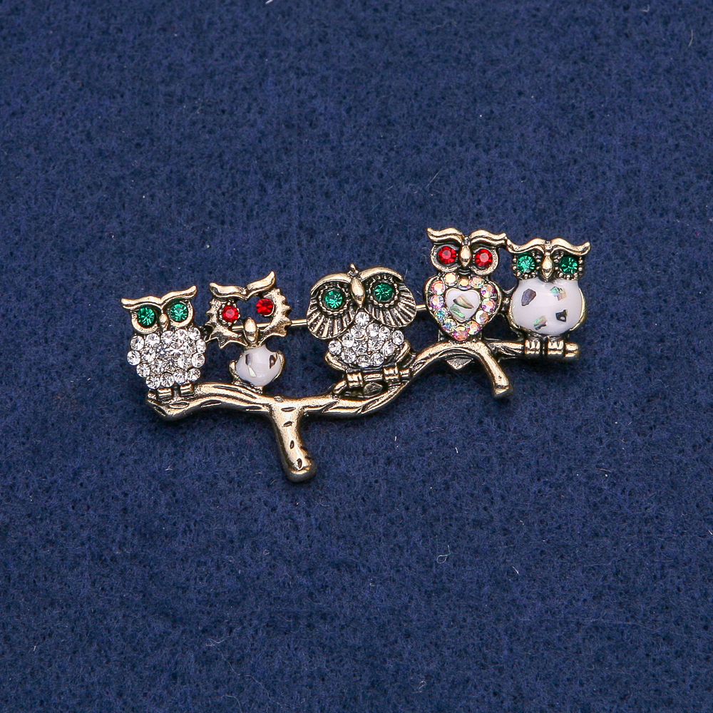 Broszka w kształcie sowy z złotym metalem, z białymi, w kolorze chameleon, czerwonymi i zielonymi kryształkami oraz haliozytem, 52×33 mm