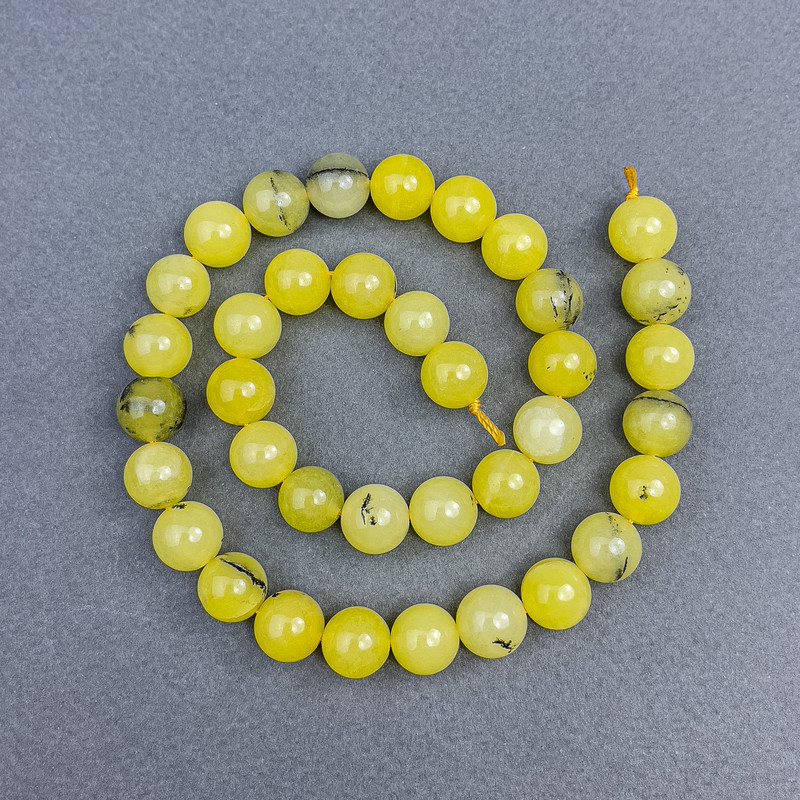 Koraliki z żółtego turkusu – gładkie kule o średnicy około 10 mm, nawleczone na nić, długość około 38 cm.
