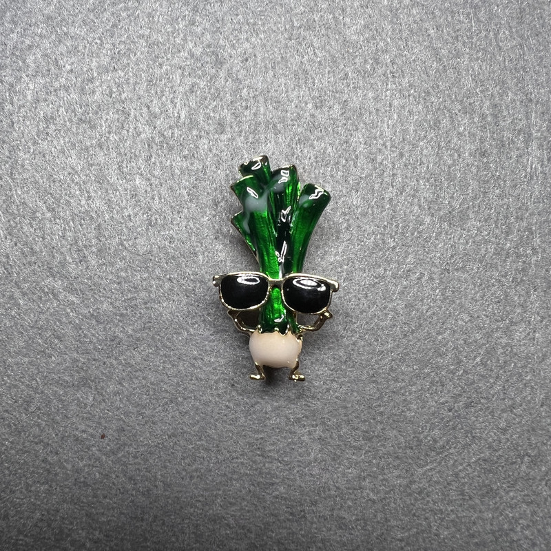 Broszka «Seler w okularach» – zielona, czarna i biała emalia, złoty metal 18×32 mm